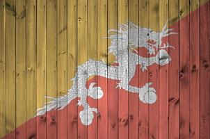 bhutan flagga avbildad i ljus måla färger på gammal trä- vägg. texturerad baner på grov bakgrund foto