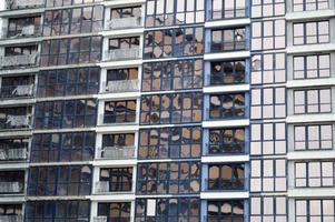 skön modern blå glas glasfiber fönster av de Fasad vägg av en modern skyskrapa byggnad hus. bakgrund, textur foto