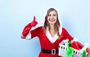 närbild av caucasian Lycklig kvinna bär santa kläder och rengöring handskar, hålla rengöring sprayer foto