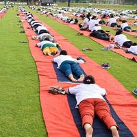 grupp yoga övning session för människor av annorlunda ålder grupper på cricket stadion i delhi på internationell yoga dag, stor grupp av vuxna delta yoga session foto