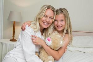 mor och dotter kramar i sängen foto