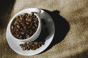 kopp fylld med rostade kaffebönor på producenten jaktpåse