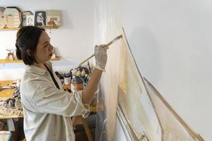 målning på tom duk, latinamerikan kvinna med borstar och olja målning foto