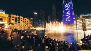 dubai, förenad arab emirates, 2022- turist Kolla på spela in de dubai fontän är de världens största koreograferad fontän systemet uppsättning på man tillverkad burj khalifa sjö foto