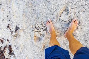 gående barfota på de strand sand förbi de vatten Mexiko. foto