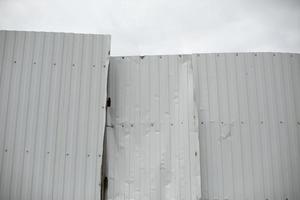 bruten stål profil staket. rynkig metall staket. vit stål barriär. foto