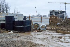 en stor modern konstruktion webbplats i de konstruktion av byggnader och hus med apparater och många stor hög torn och stationär industriell kraftfull kranar och byggnad material foto