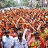 New Delhi, Indien 3 april 2022 - kvinnor med kalash på huvudet under jagannath-templet mangal kalash yatra, indiska hinduistiska hängivna bär jordkrukor som innehåller heligt vatten med en kokosnöt på toppen foto