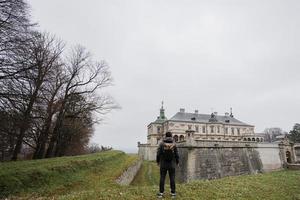 tillbaka av man turist med ryggsäck besök pidhirtsi slott, lviv område, ukraina. foto