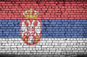 serbia flagga är målad till ett gammal tegel vägg foto