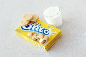 ternopil, ukraina - Maj 28, 2022 oreo gyllene Krispig småkakor med glas av mjölk på vit bakgrund. de varumärke oreo är ägd förbi företag mondelez internationell foto