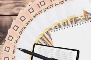 20 vitryska rubel räkningar fläkt och anteckningsblock med Kontakt bok och svart penna. begrepp av finansiell planera och företag strategi foto