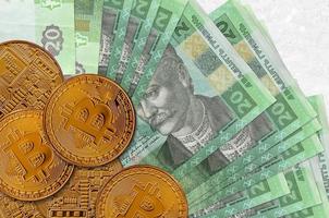 20 ukrainska hryvnias räkningar och gyllene bitcoins. kryptovaluta investering begrepp. crypto brytning eller handel foto
