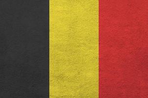 belgien flagga avbildad i ljus måla färger på gammal lättnad putsning vägg. texturerad baner på grov bakgrund foto