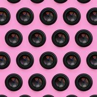 en få kamera linser med en stängd öppning lögn på textur bakgrund av mode pastell rosa Färg papper i minimal begrepp. abstrakt trendig mönster foto