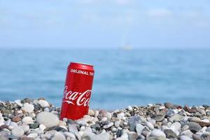 antalya, Kalkon - Maj 18, 2021 original- coca cola röd tenn kan lögner på små runda sten stenar stänga till hav Strand. Coca Cola på turkiska strand foto