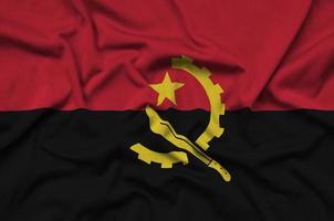 angola flagga är avbildad på en sporter trasa tyg med många veck. sport team baner foto