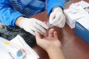 öst kutai, öst kalimantan, Indonesien, 2022 - en hälsa arbetstagare utför en finger sticka testa för hiv, selektiv fokus foto