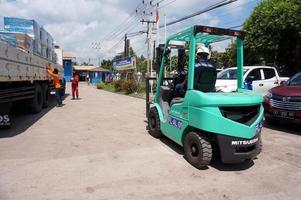 sangatta, öst kalimantan, Indonesien, 2020 - gaffeltruck förare läser in frakt lastpall sändning med en lastbil kran på perking område lager. foto