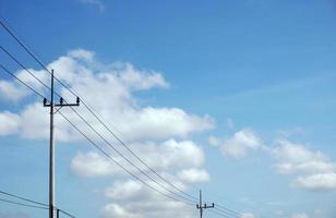 elektrisk Pol kraft rader utgående elektrisk trådar motstånd på moln blå himmel. foto