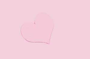 stänga upp papper kärlek form på rosa bakgrund foto