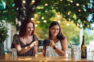 två vänner dricka kaffe - kvinnor klirr med koppar av kaffe foto