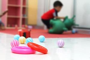 leksaker placerad på de golv med de suddig av en liten pojke spelar med dockor. foto