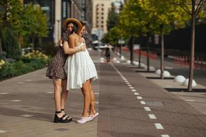 Lycklig möte av två vänner kramas i de gata foto
