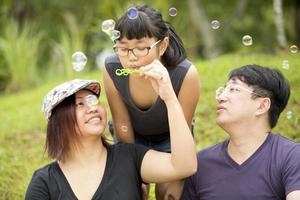 ung asiatisk tjej som spelar blåser bubblor i parkbindning