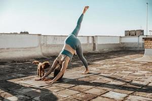 kvinna håller på med yoga utomhus på en taket terrass foto