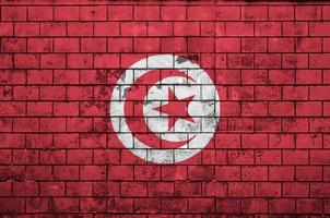 tunisien flagga är målad till ett gammal tegel vägg foto
