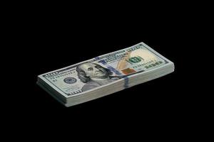 bunt av oss dollar räkningar isolerat på svart. packa av amerikan pengar med hög upplösning på perfekt svart bakgrund foto