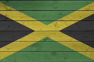 jamaica flagga avbildad i ljus måla färger på gammal trä- vägg. texturerad baner på grov bakgrund foto