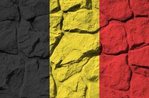 belgien flagga avbildad i måla färger på gammal sten vägg närbild. texturerad baner på sten vägg bakgrund foto