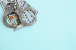 silver- polis handklovar och hundra dollar räkningar lögner på ljus blå bakgrund foto
