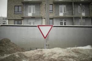 väg tecken röd triangel. tecken i snö. väg infrastruktur. vinter- på väg. foto