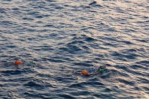 simmare simning i öppen vatten i de medelhavs hav med en säkerhet boj foto