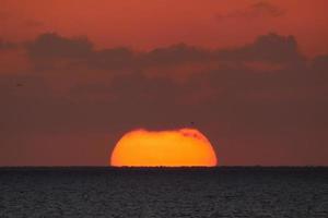 Sol disk stigande över de horisont av de hav, soluppgång, gryning foto