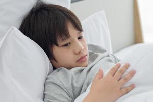 asiatisk pojke i sängen foto
