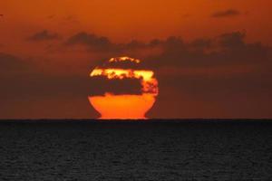 Sol disk stigande över de horisont av de hav, soluppgång, gryning foto