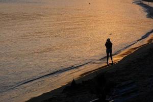 bakgrundsbelysning av en silhuett av ett anonym kvinna tar foton i de hav