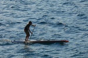 simmare på semester paddla surfing i de medelhavs hav foto