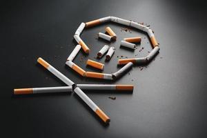 skalle från cigaretter på en svart bakgrund. de begrepp av rökning dödar. mot de begrepp av rökning som en dödligt vana, nikotin gifter, cancer från rökning, sjukdom, sluta rökning. foto