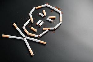 skalle från cigaretter på en svart bakgrund. de begrepp av rökning dödar. mot de begrepp av rökning som en dödligt vana, nikotin gifter, cancer från rökning, sjukdom, sluta rökning. foto