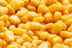 gyllene konserverad majs, som distribuerad på en plan bakgrund och textur av popcorn. innan tittar på en film topp se. närbild foto