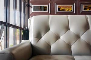 modern grå läder soffa med grunge brun och glas vägg i kaffe affär. foto