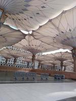 medina, saudi Arabien, 2022 - paraply konstruktion på de fyrkant av al-masjid an-nabawi eller profet muhammed moské är skyddande människor från Sol på dagtid och arbete som lampor på natt foto