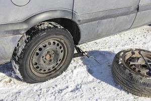 ändring en platt däck i de vinter- snö med säkerhetskopiering foto