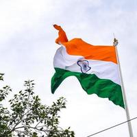 Indien flagga vajar högt på connaught plats med stolthet över blå himmel, Indien flagga vajar, indiska flaggan på självständighetsdagen och republikens dag i Indien, tilt up shot, viftande indiska flaggan, har ghar tiranga foto