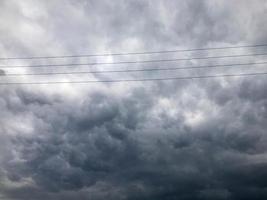 textur av svart spänd högspänning trådar för elektricitet mot en bakgrund av mörk blå trumpen storm stormig himmel med regn moln foto